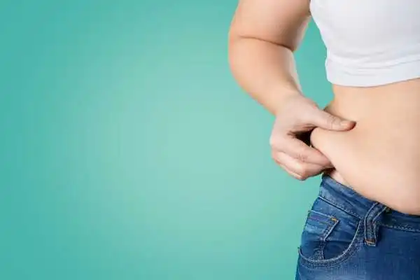 Image of woman pinching her love handles to show weight gain Harlow